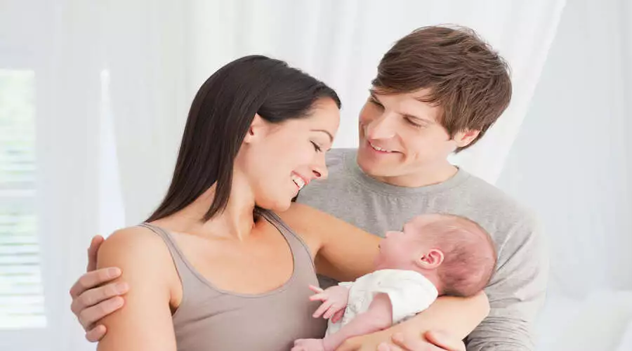 Both Parents are Holding the Infant